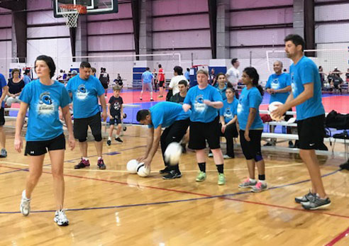 Employees playing volleyball during Corporate Challenge